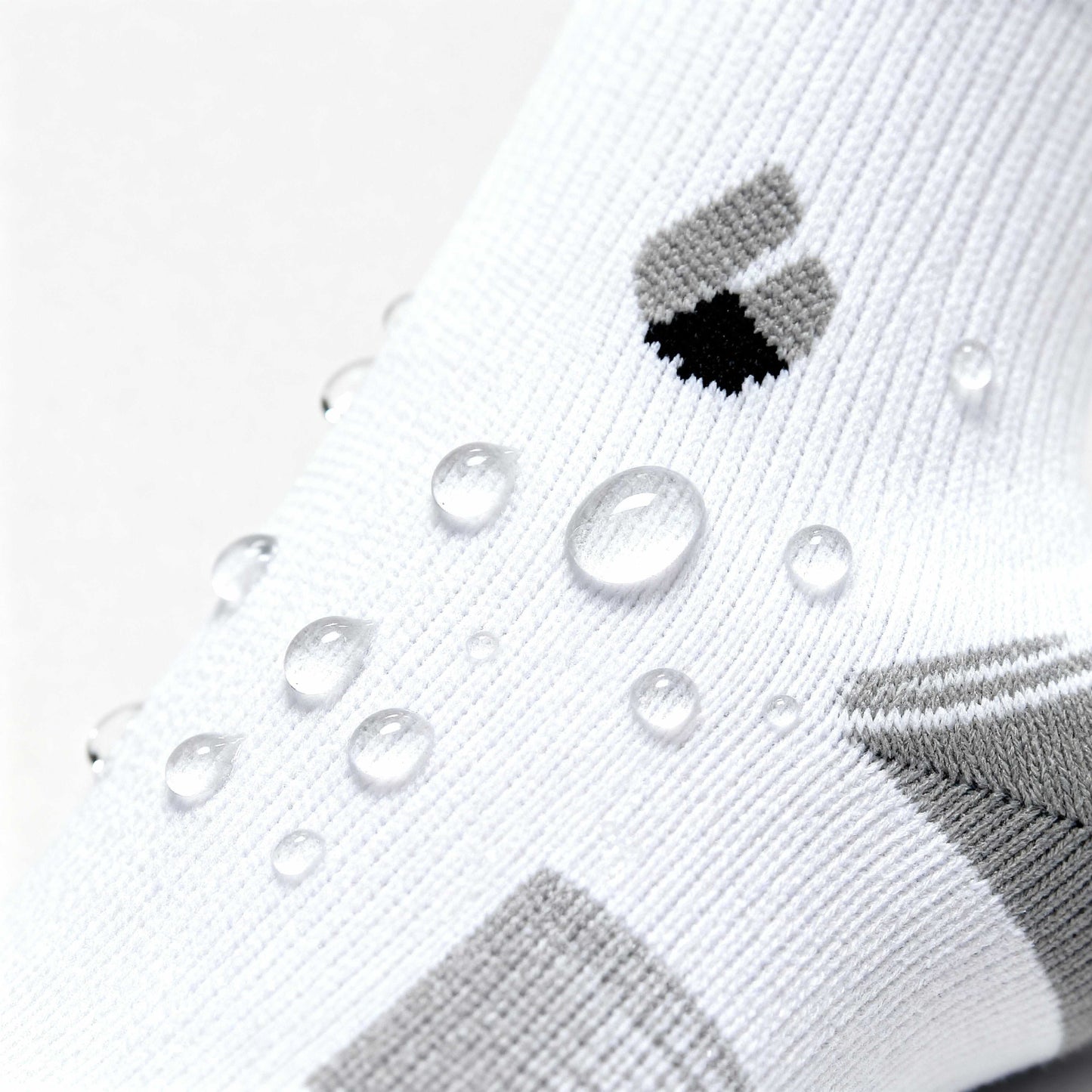 white and grey ankle running socks with water droplets showing moisture-wicking fabric detail